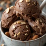 Chocolate Ninja Creami protein ice cream in a bowl with almond toppings
