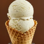A creamy scoop of vanilla bean ninja cream topped with vanilla bean specks in a waffle cone.