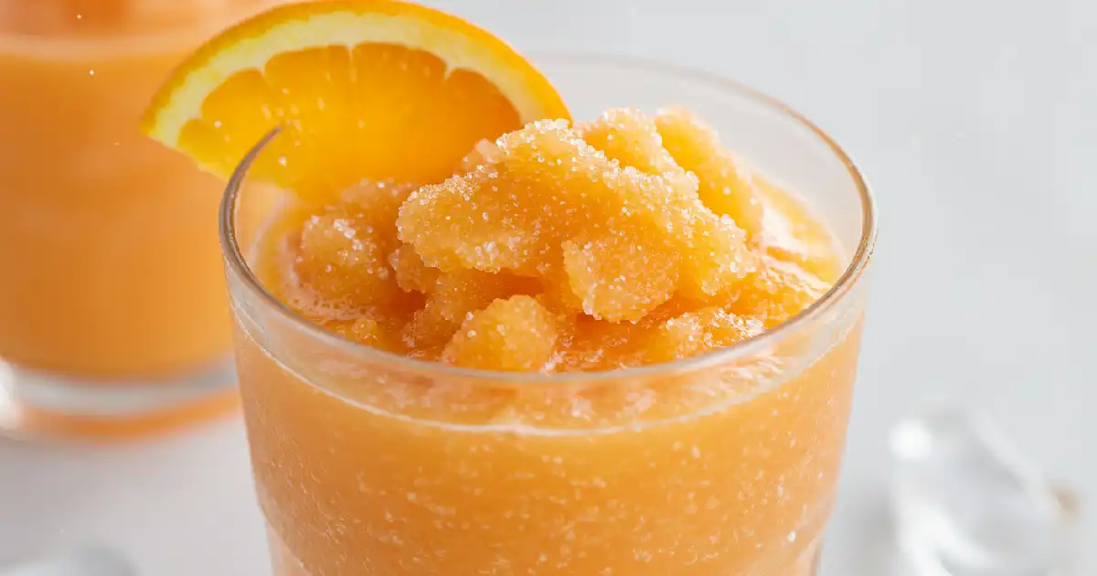 Refreshing Orange Creamsicle Ninja Slushie in a chilled glass with orange slice garnish